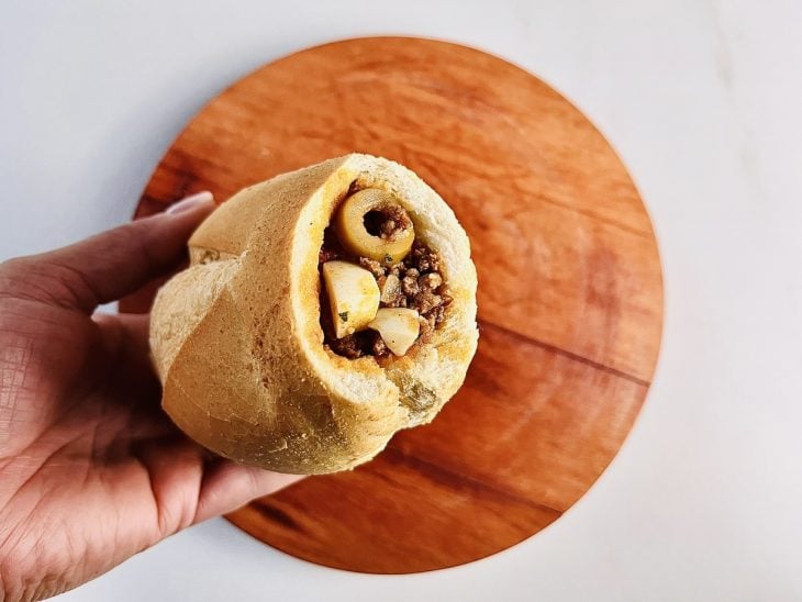 Queijo e carne moída adicionados ao pão.