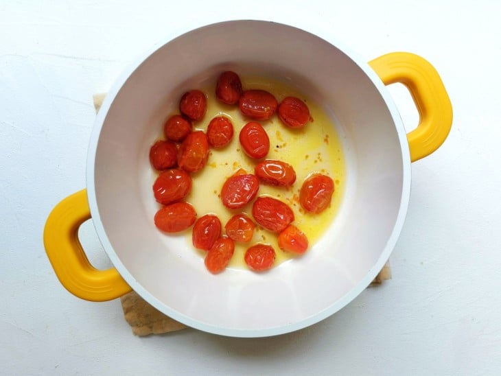 Tomate-cereja refogado no azeite em uma panela.