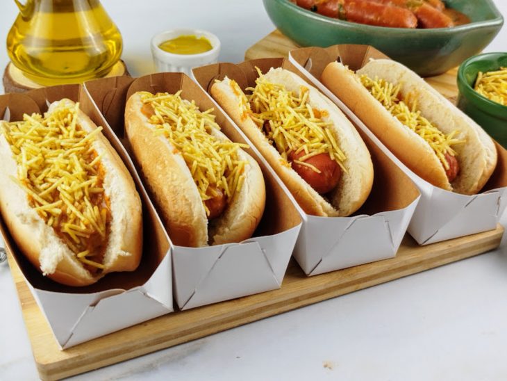 Uma bancada com cachorro-quente com molho cremoso.