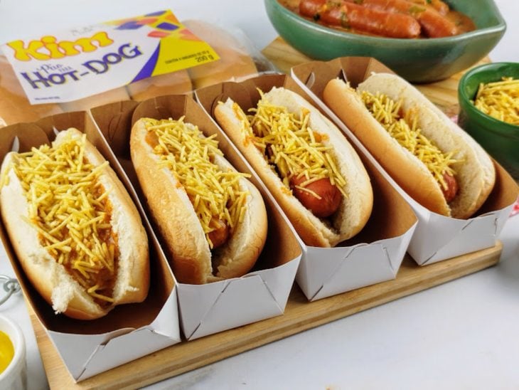 Uma bancada com cachorro-quente com molho cremoso.