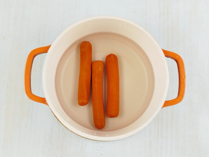 Salsichas em uma panela com água para cozimento.