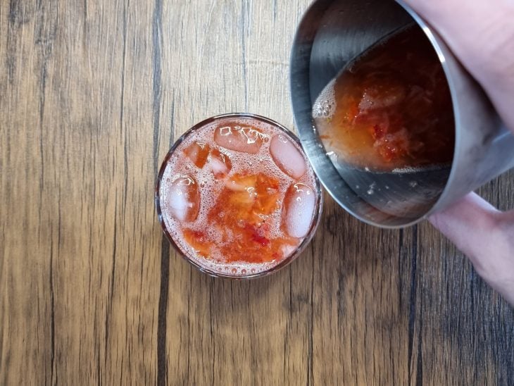 caipirinha sendo despejada da coqueteleira para o copo
