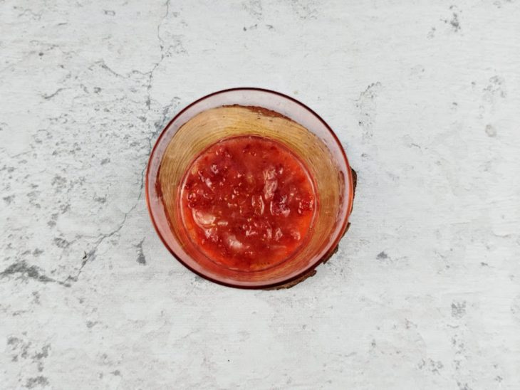 Morango macerado com açúcar em um copo.