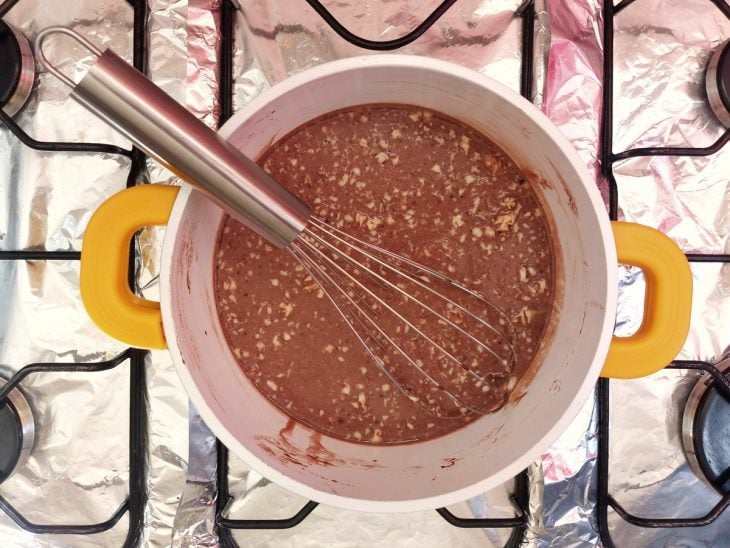 Uma panela contendo a mistura de chocolate em pó com leite condensado, manteiga e leite.