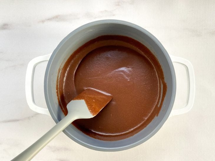 Uma panela contendo a mistura de açúcar, achocolatado, leite e manteiga.