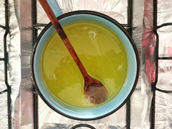 Uma panela contendo a calda de laranja ao fogo.