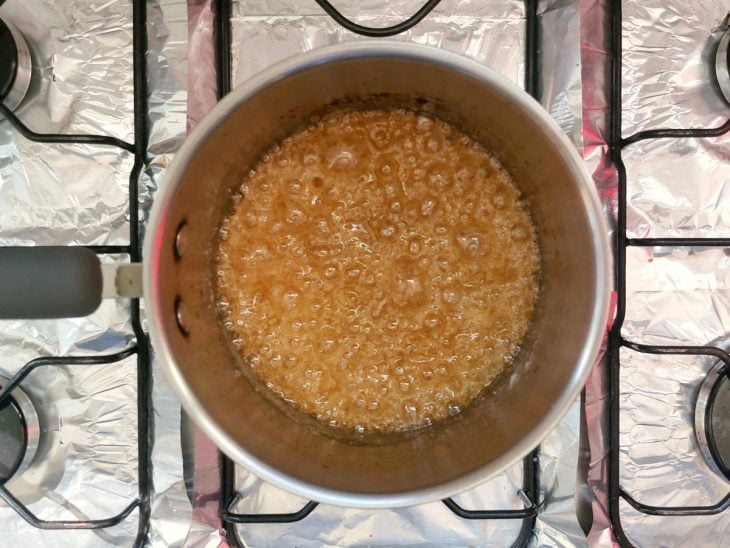 Uma panela com açúcar e água ao fogo.