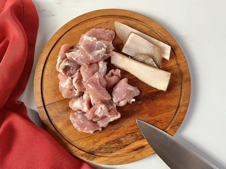 Uma tábua com costelinha e bacon picados.