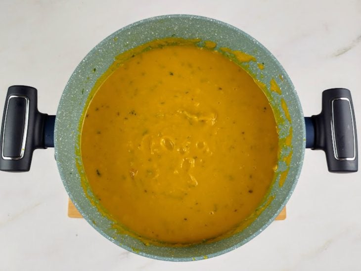 Caldo batido colocado na panela e temperado com sal e pimenta-do-reino.