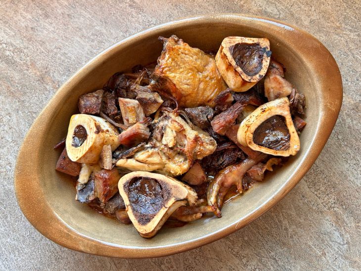 Aparas da carne e os ossos acrescentados ao frango já assado.