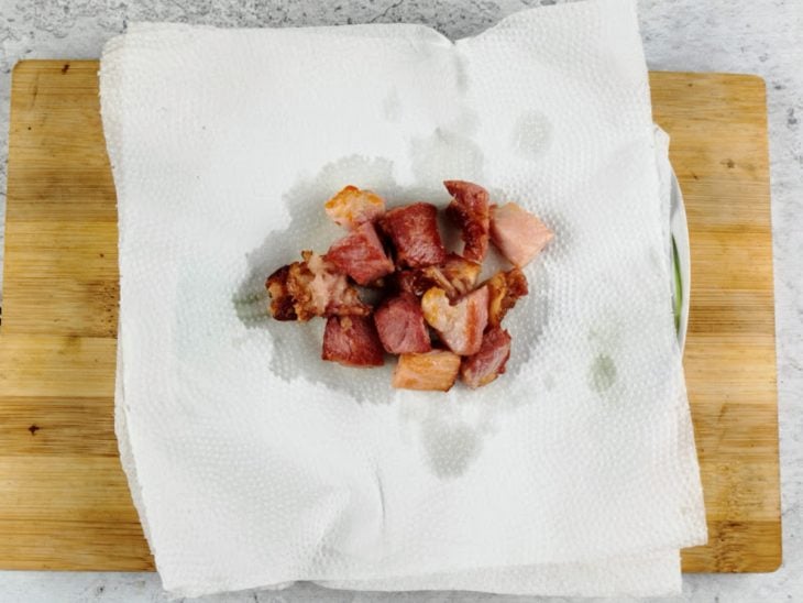 Bacon frito sobre um prato com papel toalha.