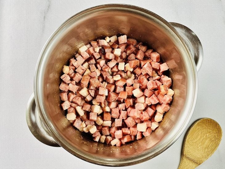 cubinhos de bacon e calabresa fritando na panela