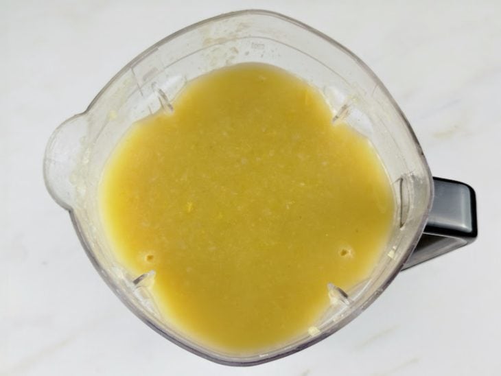 Um liquidificador com a mistura da mandioca e a água do cozimento.