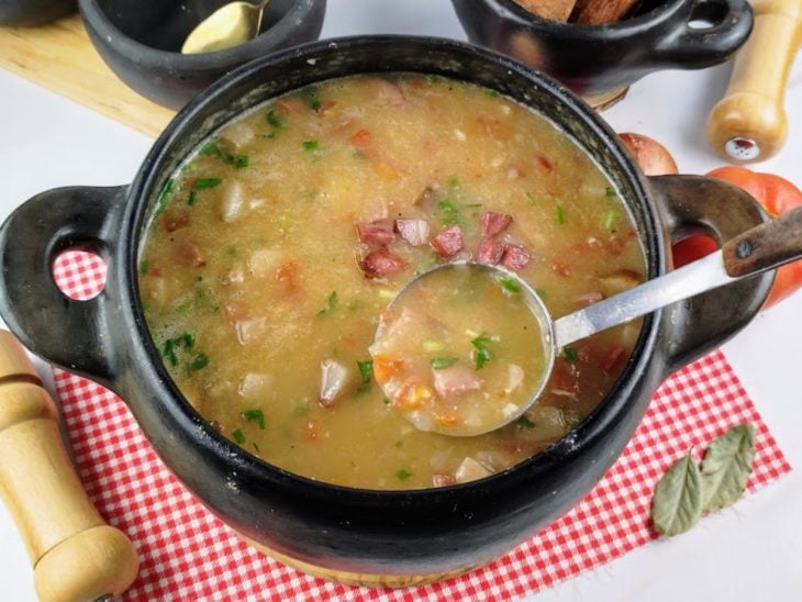 Uma panela contendo o caldo de mandioca com calabresa.