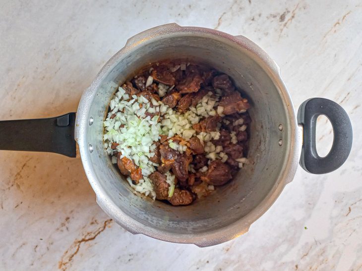 Cebola adicionada a panela de pressão.