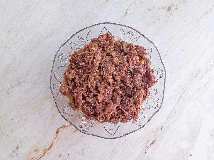 Carne desfiada em uma tigela de vidro.