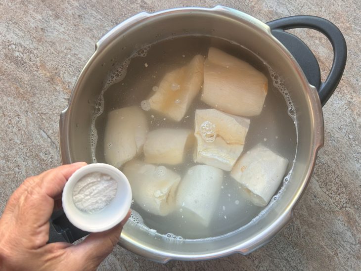 Uma panela com a mandioca, água e sal.