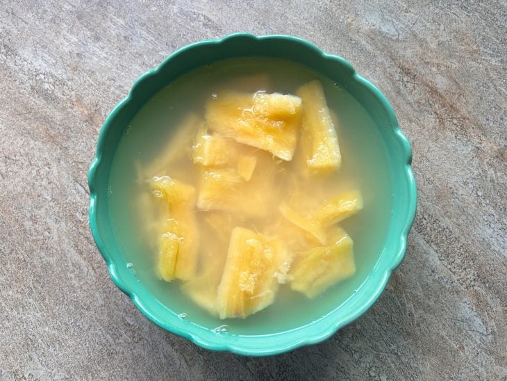 Uma tigela com água e mandioca cozida.