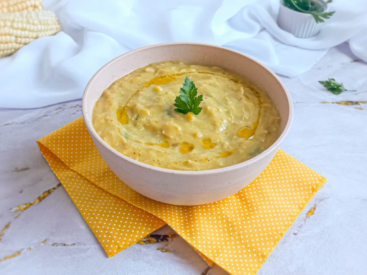 Caldo de milho-verde servido em um recipiente redondo rosa.