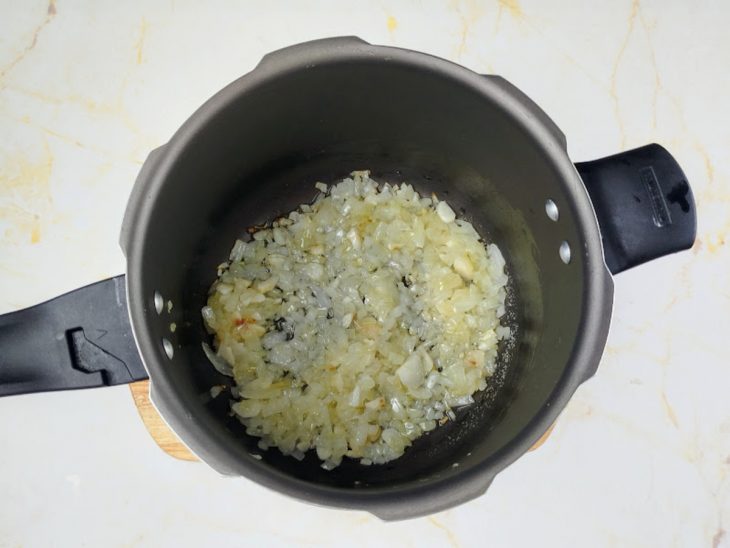Panela com azeite, cebola e alho refogados.