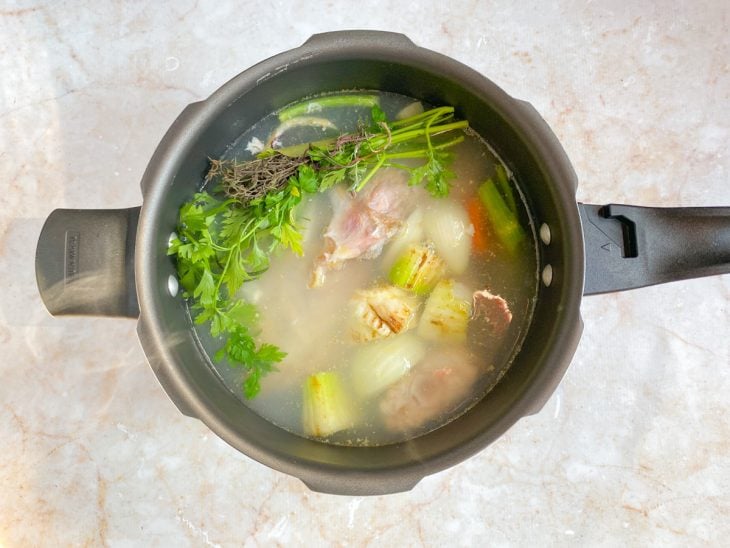 Uma panela com os ingredientes do caldo.