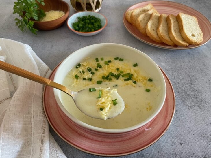 Caldo pronto e decorado com cebolinha.