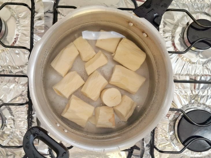Pedaços de mandioca em água para cozinhar.