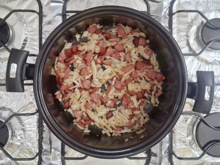 Cebola e alho adicionados na panela.