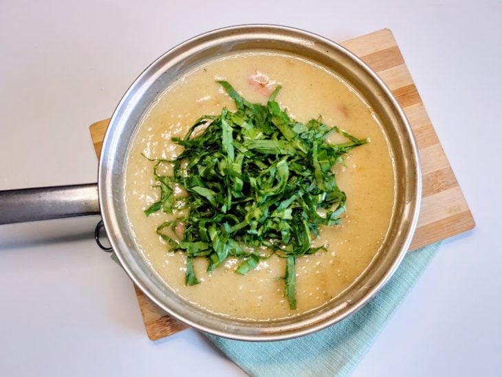 Uma panela contendo caldo verde com couve.