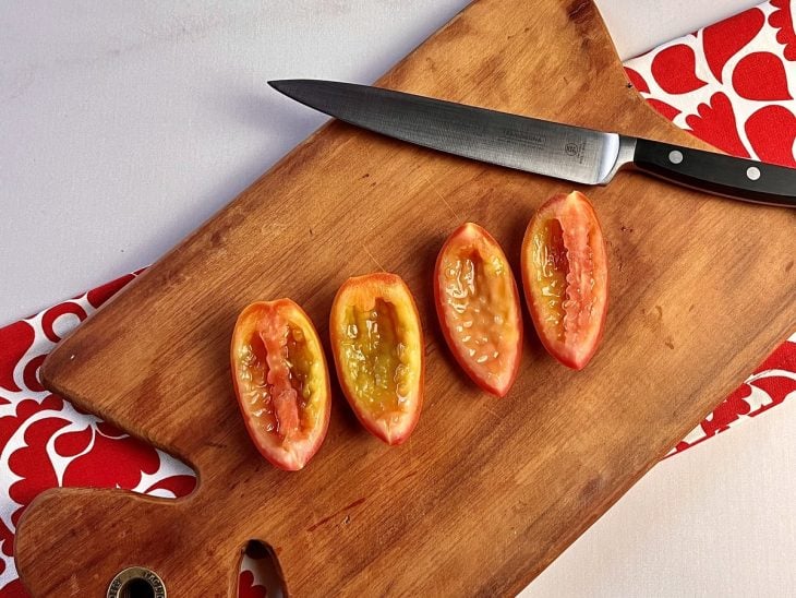 Uma tábua contendo tomates cortados sem sementes.