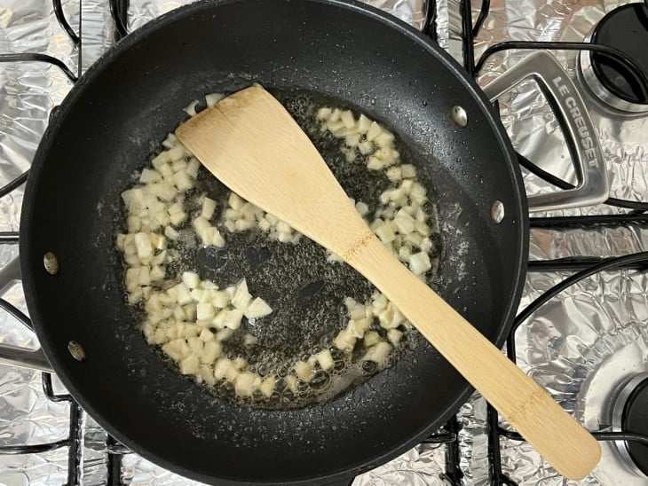 Frigideira com temperos refogando.