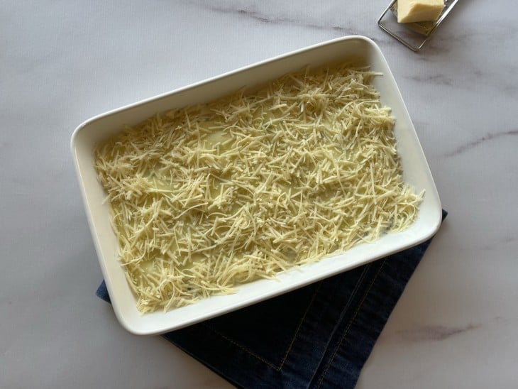 Camarão ao Catupiry em uma travessa salpicado com parmesão ralado.