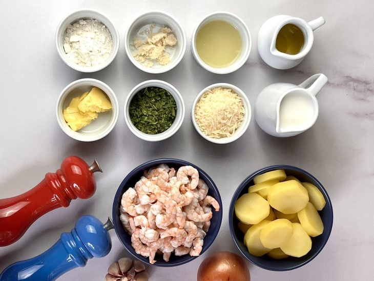 Ingredientes do camarão ao molho branco gratinado com batata reunidos.