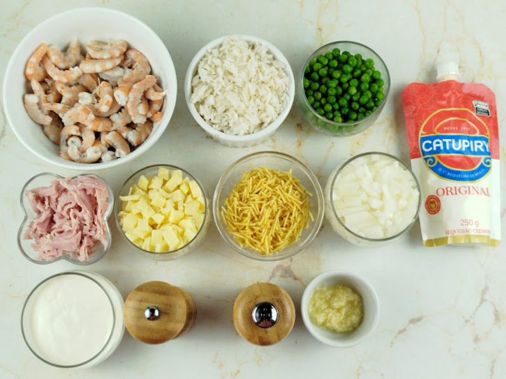 Ingredientes organizados na bancada com camarões limpos e itens picados.