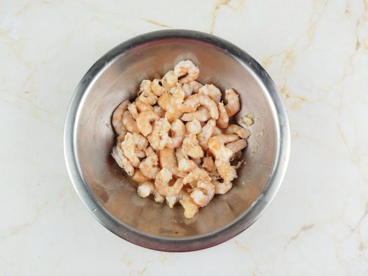 Camarões refogando rapidamente no azeite até ficarem levemente dourados.