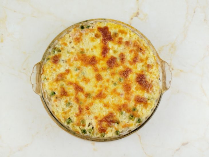 Prato saindo do forno com queijo gratinado e dourado.