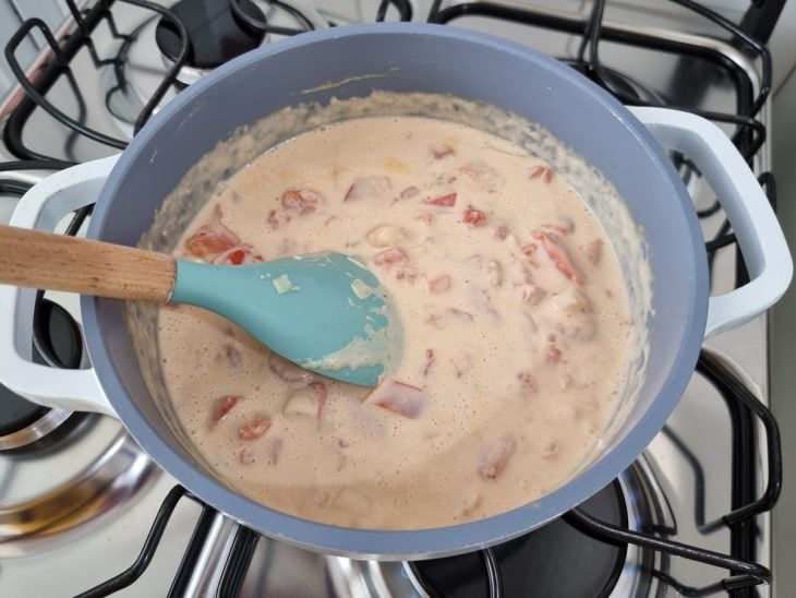 Panela com creme branco, temperos e camarões.