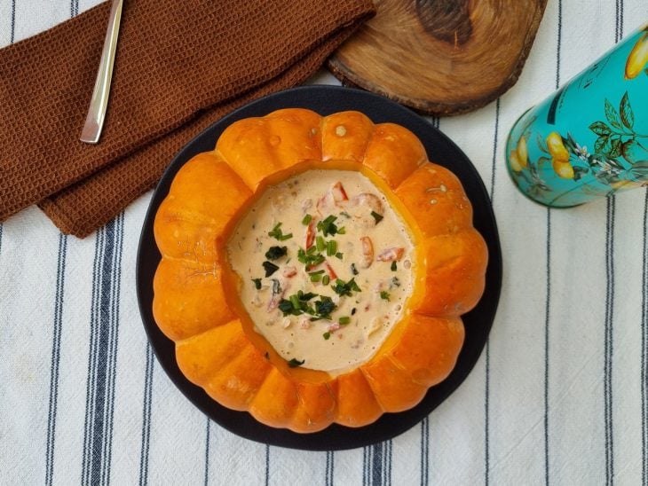 Abóbora moranga com creme de camarão dentro e cheiro-verde salpicado.