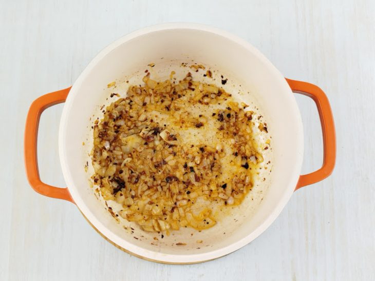 Ingredientes refogados numa panela.