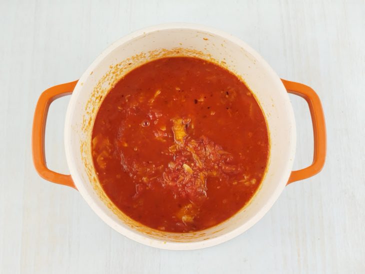 Polpa de abóbora e tomates pelados adicionados na panela.