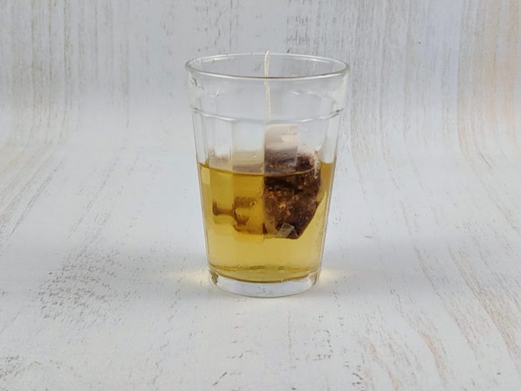 Sachê de chá em infusão na água.