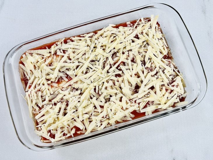 Queijo parmesão salpicado sobre a superfície.