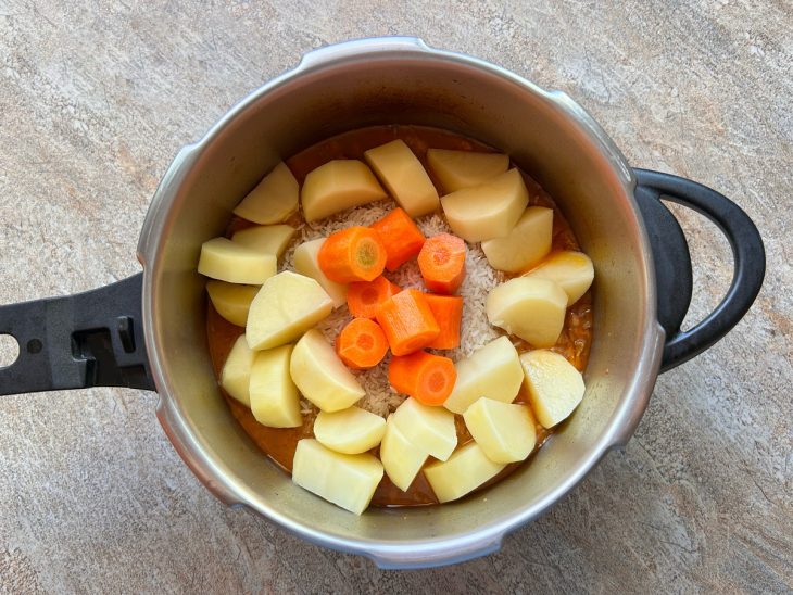 adição de arroz, batata e cenouras ao preparo da canja de galinha.
