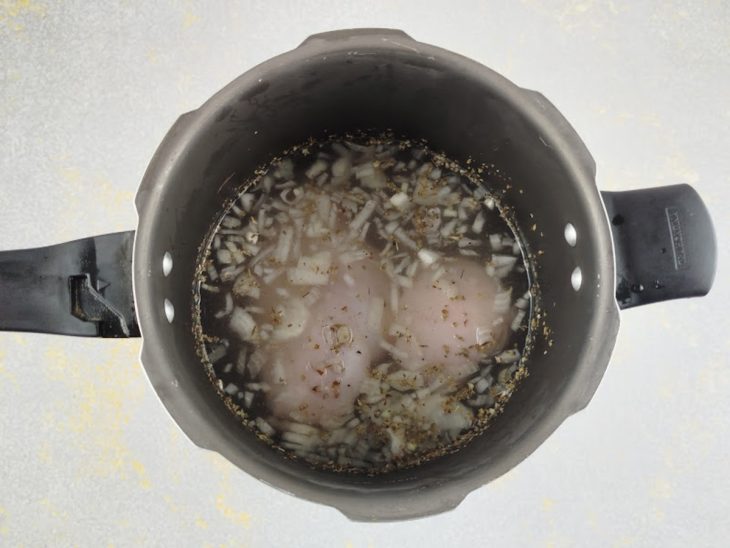 Frango cozinhando na panela de pressão.