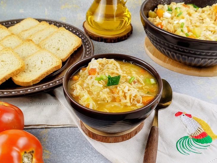 Canja de galinha com legumes servida.