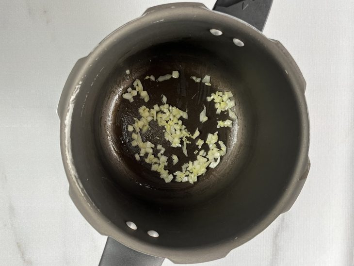 cebola e alho refogados em panela de pressão.