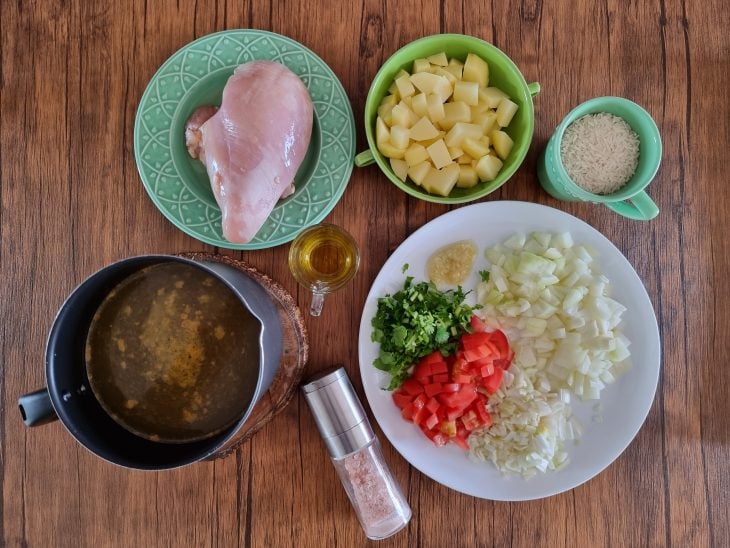 Ingredientes da canja de galinha simples reunidos na bancada.