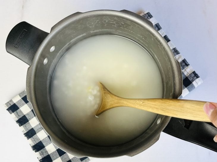Uma panela de pressão contendo água e canjica.