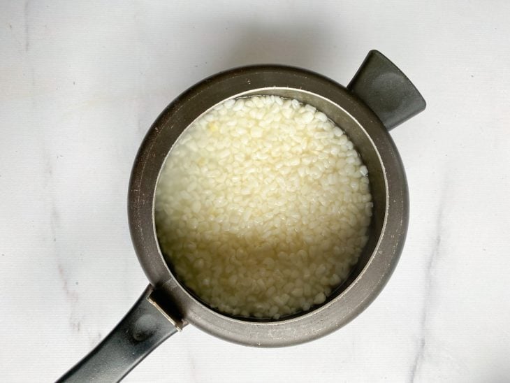 Uma panela de pressão com canjica e água.