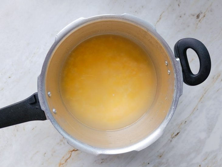 Grãos de canjica sendo deixados de molho na panela.